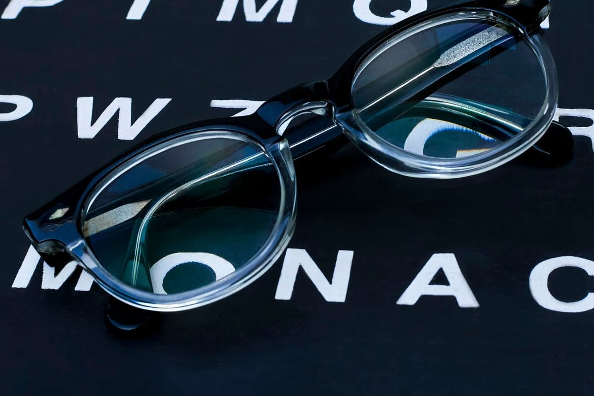 A pair of glasses resting on an eye-test chart